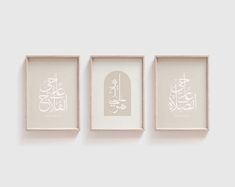 three framed pictures hanging on the wall with arabic writing in white and beige frames above them