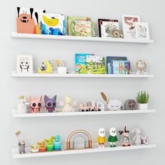 three white shelves filled with books and toys