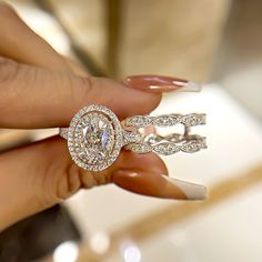 a woman's hand holding two diamond rings