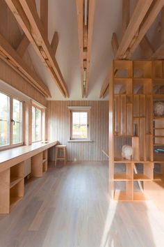 an empty room with wooden shelves and windows