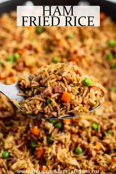 a spoon full of fried rice with peas and carrots