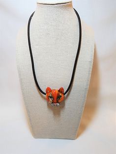 "Unique hand-made glass lioness head pendant in various shades of orange, white, and black. Red heart on reverse. Measures 1.5\" tall, 1.25\" wide. On a black cord that is 16\" long plus a 1.5\" extender." Hand Painted Adjustable Orange Jewelry, Adjustable Hand Painted Orange Jewelry, Shades Of Orange, Heart On, Orange White, Red Heart, Pendant Necklaces, Black Red, Jewelry Necklace Pendant