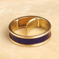 This unassuming gold and blue enamel ring is so much more than meets the eye. Dating to the Regency period, this elegant piece is mourning ring engraved with the following details: "J. D. died 24th May 1825 Aged 84." The interior golds a hinged locket which once would have held plaited hair of the deceased but is now empty. This style of concealed locket mourning ring is quite unusual and very very special. It is a size 6 and cannot be resized. ((details)) Materials: 18k yellow gold, blue enamel Blue 14k Gold Enamel Ring For Formal Events, Blue 14k Gold Enamel Ring For Formal Occasions, Formal Blue Enamel Ring In 14k Gold, Elegant Yellow Gold Enamel Signet Ring, Formal Yellow Gold Black Enamel Ring, Formal Yellow Gold Ring With Black Enamel, Formal Yellow Gold Enamel Ring With Black Details, Gold Open Enamel Ring For Formal Occasions, Elegant Formal Enamel Signet Ring