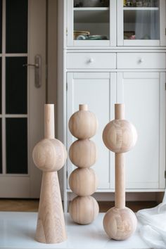 three wooden sculptures sitting on top of a white table