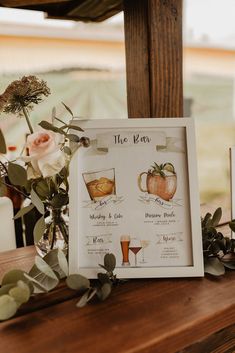 a table topped with flowers and drinks on top of a wooden table