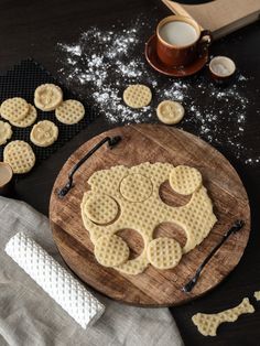 some waffles are sitting on a wooden board next to a cup of coffee