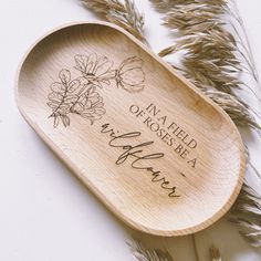 a wooden spoon with the words in a field of roses on it