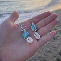 💕These gorgeous little dainty sterling silver turtle earrings are the perfect beachy accsessory! 💕Made from recycled sterling silver and features a ceramic turtle charm and cowrie shell. 💕Nickel and lead free. 💕 Please avoid contact with water, perfume,oils and other chemicals in order to prolong the life. Wire Turtle Earrings, Ocean-inspired Sterling Silver Beach Jewelry, Handmade Beachy Earrings As Gift, Handmade Beachy Earrings For Gift, Handmade Dainty Jewelry For The Beach, Handmade Ocean Color Jewelry For Summer, Dainty Handmade Beach Jewelry, Handmade Ocean Color Summer Jewelry, White Jewelry For Beach Season Gift