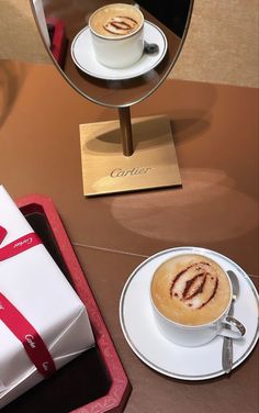 a cappuccino in a white cup on a saucer with a red ribbon