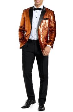 Drenched in golden sequins and finished with satin lapels, the jacket of this entrance-making tuxedo pairs with pleated black trousers and a coordinating bow tie to finish the standout look. Jacket has peaked lapels; four-button cuffs; chest pocket; welt pockets; interior pockets; side vents Trousers have zip fly with button-tab closure; slant pockets; back pockets Jacket is lined Unhemmed 100% polyester Machine wash, line dry Imported Gold Tailored Tuxedo For Formal Occasions, Glamorous Long Sleeve Evening Suit, Glamorous Tailored Long Sleeve Suits, Gold Fitted Tuxedo For Formal Occasions, Festive Fitted Gold Tuxedo, Fitted Sequined Suits For Parties, Tailored Glamorous Evening Suits, Glamorous Sequined Suits For Night Out, Glamorous Tailored Evening Suits