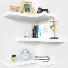 two white shelves with books, an alarm clock and other items on top of them