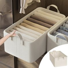 an open drawer with clothes hanging on it and a hand pointing at the bottom shelf