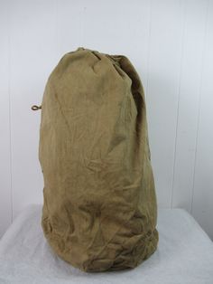 "Vintage 1920s or 30s military duffel bag tote. Made of khaki cotton micro herringbone twill. Has double stitched seams and a rope drawstring. Faded U.S. Arm spec tag. Bag measures 29\" tall. Bottom is 16\" in diameter. In very good condition with mild patina from age." Shoe Bags, Us Army, Vintage Bags, Duffel Bag, Laundry Bag, Herringbone, Etsy Vintage, Tote Bag, Clothes