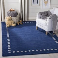 a blue rug with white polka dots on it in a living room next to a chair and teddy bear