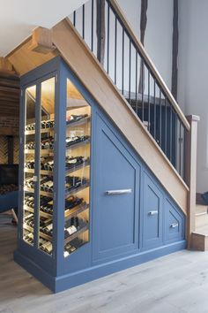 a wine cellar under the stair case in a room with wooden flooring and stairs