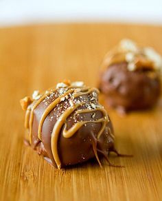 two chocolate covered desserts sitting on top of a wooden table