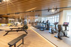 a gym with treadmills, exercise machines and other equipment in the area that is well lit