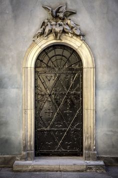 an ornate door with birds on it in front of a building