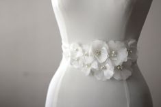 a white dress with flowers and pearls on it