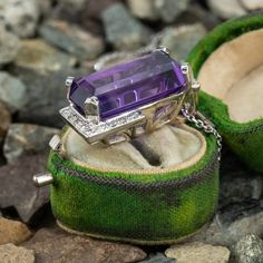 This stunning 14K white gold pendant is centered with one (1) cut-cornered rectangular step cut natural amethyst set into a four-prong setting. The amethyst is bordered with eighteen (18), bead set, round brilliant cut diamonds. The pendant measures 27.0mm X 16.9mm X 13.3mm and is suspended from a 14K white gold cable link style neck chain measuring 18 inches in length. Luxury Purple Amethyst Ring, Rectangular Shape, Luxury Purple Amethyst Rectangular Ring, Luxury Purple Rectangular Amethyst Ring, Formal Purple Amethyst Ring With Rectangular Shape, Formal Rectangular Amethyst Ring, Formal Rectangular Purple Amethyst Ring, Luxury Rectangular Amethyst Ring, Luxury Rectangular Amethyst Ring As A Gift, Luxury Rectangular Amethyst Ring For Gift