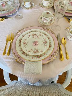 the table is set with pink and gold china