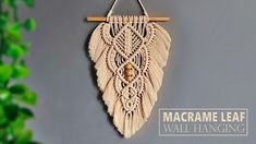 the macrame leaf wall hanging is made from natural materials and has a wooden stick attached to it