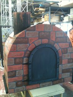 a man standing next to a brick oven