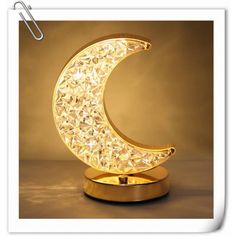 a golden moon shaped lamp on top of a table