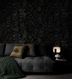 a living room with a couch, lamp and wallpaper