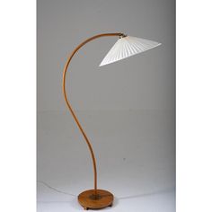 a lamp that is on top of a wooden stand with a white shade over it