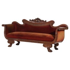 an ornate wooden couch with red velvet upholstered