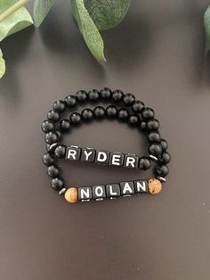 - Sleek and modern boys name bracelet with matte black onyx beads. Suitable for baby, toddler, or school age boys. Personalize with name, initials, nickname, sport ect... Lightweight stretch bracelet is beaded on high quality stretch cord and secured. -  Choice of all black or black with brown bead accent. Please leave name or wording in personalization box. - 5.5 matte black onyx beads   6mm picture jasper beads   6mm acrylic letter cubes     hematite spacer beads ‼️Young children MUST be supervised at all times while wearing jewelry. Contains small parts that could be a potential choking hazard. Jewelry should always be removed during sleep. Never leave young children unattended with our products. Supervision is required. It is at the customers discretion for the use of our products.  - Personalized Black Beaded Bracelets For Father's Day, Personalized Black Name Jewelry, Personalized Black Jewelry With Name, Personalized Name Bracelet In Black, Personalized Black Name Bracelet, Personalized Black Jewelry For Birthday, Custom Name Black Wristband As Gift, Black Custom Name Wristband As Gift, Custom Name Black Bracelet For Birthday