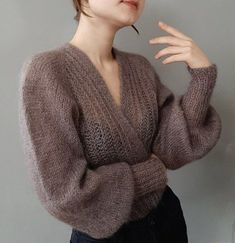 a woman with short hair wearing a brown sweater