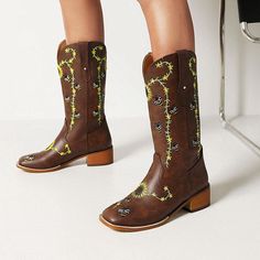 Looking for a unique and stylish pair of cowboy boots? Check out our Sunflower Field Cowboy Boots! These beautiful boots are made from vegan PU Leather, and feature sunflower field stitched motifs. They're perfect for a boho outfit and have a square heel that looks great with skinny jeans or shorts. Specs: Material: PU Leather Fits true to size Square Toe Heeled Boots For Western-themed Fall Events, Fall Square Toe Heeled Boots For Western-themed Events, Spring Rodeo Moto Boots With Round Toe, Brown Floral Print Boots For Fall, Western Summer Boots With Round Toe, Trendy Summer Boots For Rodeo, Western Heeled Boots For Summer Rodeo, Summer Rodeo Round Toe Heeled Boots, Western Style Summer Heeled Boots With Round Toe