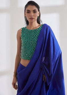 Color block your outfit with the chandelier top which is hand embroidered over a span of 8 days. The masai godet sari is pre draped and has a built in petticoat. Georgette Tops With Traditional Drape And Dupatta, Traditional Tops With Sheer Dupatta Drape, Traditional Tops With Sheer Dupatta, Traditional Drape Tops With Dupatta For Festivals, Tops With Dupatta For Festivals In Traditional Drape, Blue Cotton Silk Blouse Piece With Sheer Dupatta, Fusion Style Silk Pre-draped Saree With Cutdana, Silk Draped Blouse With Mirror Work, Fusion Style Silk Pre-draped Saree With Traditional Drape