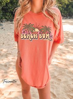 "Discover our Sun-Kissed Comfort Color Shirts, the ultimate summer wardrobe essential, designed to enhance your beach vibes and create unforgettable summer memories! Featuring a range of eye-catching designs inspired by sun-soaked beaches, tropical paradise, and endless summer adventures, our shirts will have you daydreaming about your next beach escape. Dive into a world of surf, sand, and salty sea breeze with our vibrant collection of t-shirts that embrace the aloha spirit and coastal living Casual Short Sleeve T-shirt For Beach Season, Spring Vacation T-shirt With Crew Neck, Pink Palm Tree Print Short Sleeve Top, Summer Short Sleeve Printed Tops, Relaxed Fit Cotton T-shirt For Vacation, Casual Short Sleeve Tops For Warm Weather, Pink Tropical T-shirt For Summer, Summer Cotton T-shirt With Palm Tree Print, Summer Orange Cotton Shirt