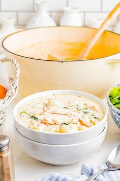 a bowl of soup next to two bowls of salad