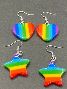 These bright colorful rainbow heart and star earrings are a must have for any fashionista  Each star or heart dangles from a hypoallergenic hook Lightweight  Each star is approximately 1 inch by 1 inch  Each heart is approximately 1 inch by 1 inch 3 options to choose from  Rainbow colored hearts  Rainbow colored stars  Rainbow heart and star mix ( 1 star & 1 heart) Jewelry Making Business, Colored Earrings, Retro Candy, Earrings Star, Scene Outfits, Black Rainbow, Rainbow Star, Funky Outfits, Earrings Heart