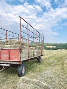 an old red trailer with hay in the back