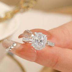 a woman's hand holding an engagement ring with two pear shaped diamonds on it