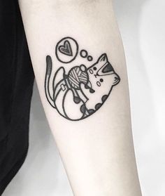 a black and white cat tattoo on the left arm, with a ball of yarn in it's mouth