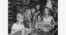 young people sitting at a table with food in front of them, posing for the camera