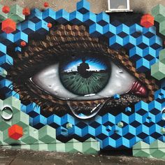 an eye painted on the side of a building with geometric patterns and dots around it