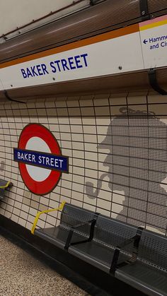 an empty bench in front of a wall with the word baker street painted on it