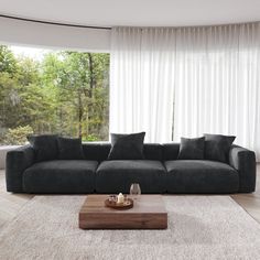 a living room with a large gray couch and coffee table in front of the window