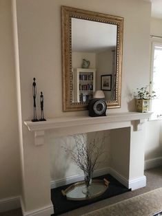 a living room with a fire place and a mirror on the fireplace mantels