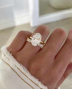 a woman's hand with a ring on it and a diamond in the middle