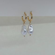 Beautiful earrings with freshwater pearls. Since the pearl is a natural freshwater pearl, no two pearls are exactly the same shape. The gold hoop earrings add to her elegant look and the earrings go perfectly with an elegant outfit, but can also be worn every day. What makes our jewelry special? 🌊 The high-quality, gold-plated stainless steel makes the jewelry waterproof ✨ No discoloration, no green edges 🌿 Allergy-friendly 🫀 each piece of jewelry is selected with love and lovingly packaged ? Everyday Pearl White Pearl Earrings, Everyday White Pearl Pendant Earrings, Everyday Hypoallergenic Pearl White Pearl Earrings, Minimalist Baroque Pearl Chain Earrings, Delicate Baroque Pearl Earrings With Pearl Charm, Gold Pearl Huggie Jewelry, Delicate White Gold Plated Pearl Earrings, Gold Pearl Pendant Earrings For Everyday, Everyday Gold Pearl Pendant Earrings