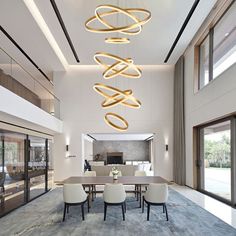 a modern dining room with large chandelier hanging from the ceiling