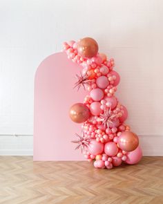 a pink and gold balloon tree on the floor